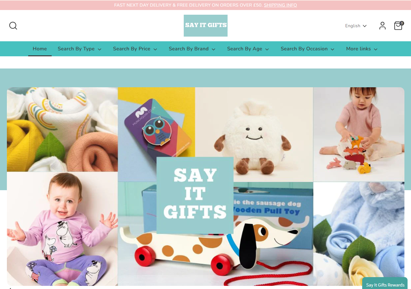 SAY IT GIFTS online store homepage showing a collage of baby and children's toys, including a plush toy, a pull toy, and baby clothing, with the SAY IT GIFTS logo at the top.